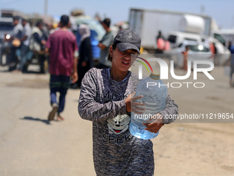 Displaced Palestinians are filling jerrycans with water at a desalination plant in Deir el-Balah in the central Gaza Strip, on May 8, 2024,...