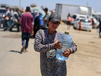 Displaced Palestinians are filling jerrycans with water at a desalination plant in Deir el-Balah in the central Gaza Strip, on May 8, 2024,...