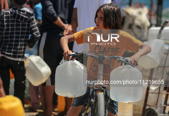 Displaced Palestinians are filling jerrycans with water at a desalination plant in Deir el-Balah in the central Gaza Strip, on May 8, 2024,...