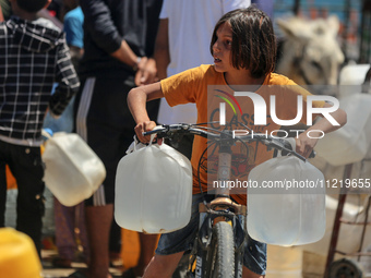 Displaced Palestinians are filling jerrycans with water at a desalination plant in Deir el-Balah in the central Gaza Strip, on May 8, 2024,...