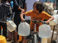 Displaced Palestinians are filling jerrycans with water at a desalination plant in Deir el-Balah in the central Gaza Strip, on May 8, 2024,...