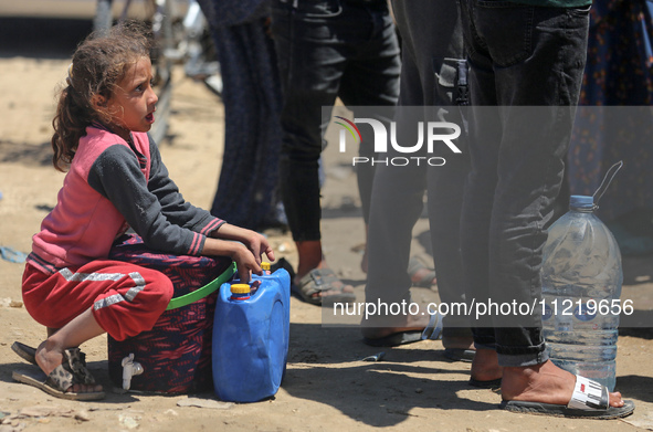 Displaced Palestinians are filling jerrycans with water at a desalination plant in Deir el-Balah in the central Gaza Strip, on May 8, 2024,...