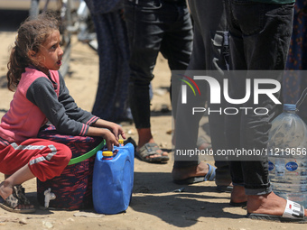 Displaced Palestinians are filling jerrycans with water at a desalination plant in Deir el-Balah in the central Gaza Strip, on May 8, 2024,...