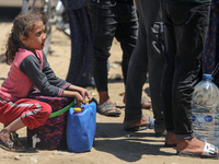 Displaced Palestinians are filling jerrycans with water at a desalination plant in Deir el-Balah in the central Gaza Strip, on May 8, 2024,...