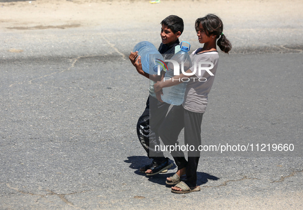 Displaced Palestinians are filling jerrycans with water at a desalination plant in Deir el-Balah in the central Gaza Strip, on May 8, 2024,...