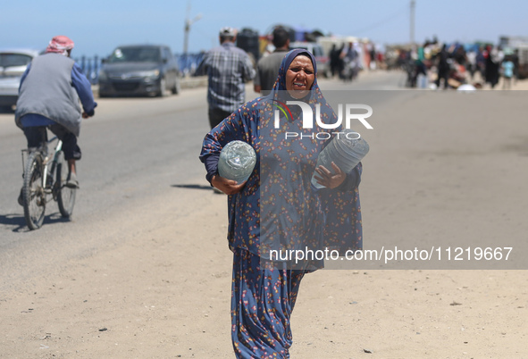 Displaced Palestinians are filling jerrycans with water at a desalination plant in Deir el-Balah in the central Gaza Strip, on May 8, 2024,...