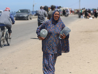 Displaced Palestinians are filling jerrycans with water at a desalination plant in Deir el-Balah in the central Gaza Strip, on May 8, 2024,...