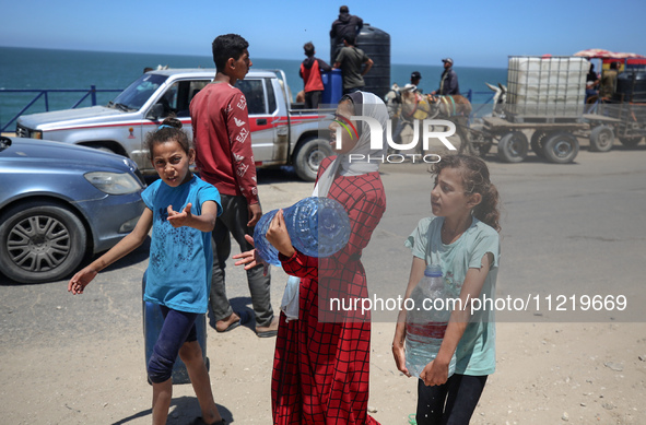 Displaced Palestinians are filling jerrycans with water at a desalination plant in Deir el-Balah in the central Gaza Strip, on May 8, 2024,...