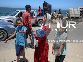 Displaced Palestinians are filling jerrycans with water at a desalination plant in Deir el-Balah in the central Gaza Strip, on May 8, 2024,...