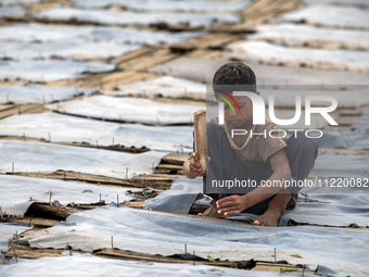 Bablu, who is 8 years old, is working at a tannery to earn one dollar a day in a low-income area in Dhaka, Bangladesh, on May 8, 2024. Altho...