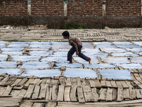 Bablu, who is 8 years old, is working at a tannery to earn one dollar a day in a low-income area in Dhaka, Bangladesh, on May 8, 2024. Altho...