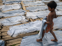 A child is carrying leather pieces to dry them at a tannery in a low-income area in Dhaka, Bangladesh, on May 8, 2024. Despite the labor law...