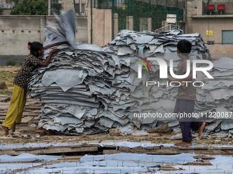 A child is carrying leather pieces to dry them at a tannery in a low-income area in Dhaka, Bangladesh, on May 8, 2024. Despite the labor law...