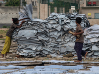 A child is carrying leather pieces to dry them at a tannery in a low-income area in Dhaka, Bangladesh, on May 8, 2024. Despite the labor law...