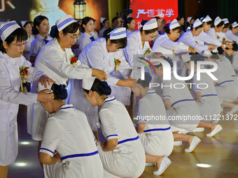 Senior nurses are giving hats to students during a hat-awarding ceremony at a nursing school in Yantai, Shandong Province, China, on May 8,...