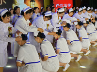 Senior nurses are giving hats to students during a hat-awarding ceremony at a nursing school in Yantai, Shandong Province, China, on May 8,...