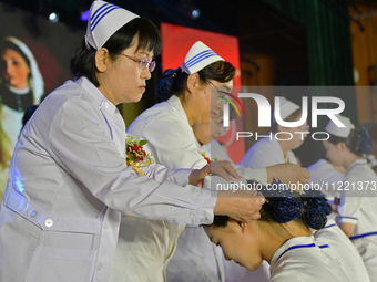 Senior nurses are giving hats to students during a hat-awarding ceremony at a nursing school in Yantai, Shandong Province, China, on May 8,...