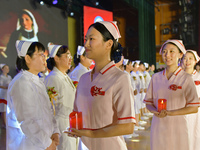 Students are holding red candles, a symbol of dedication, during a hat-giving ceremony at a nursing school in Yantai, Shandong Province, Chi...