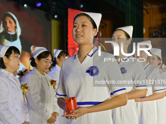 Students are holding red candles, a symbol of dedication, during a hat-giving ceremony at a nursing school in Yantai, Shandong Province, Chi...