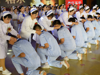 Senior nurses are giving ribbons to students during a hat-awarding ceremony at a nursing school in Yantai, Shandong Province, China, on May...