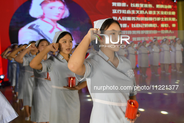 Students are taking an oath during a hat conferring ceremony at a nursing school in Yantai, Shandong Province, China, on May 8, 2024. 