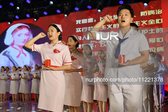 Students are taking an oath during a hat conferring ceremony at a nursing school in Yantai, Shandong Province, China, on May 8, 2024. 