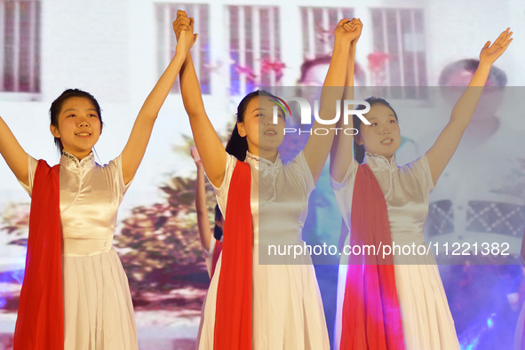 Students are performing a sign language dance during a hat conferring ceremony for Nurses' Day at a nursing school in Yantai, Shandong Provi...