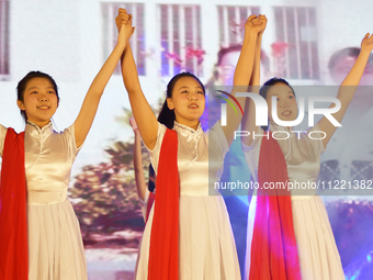 Students are performing a sign language dance during a hat conferring ceremony for Nurses' Day at a nursing school in Yantai, Shandong Provi...