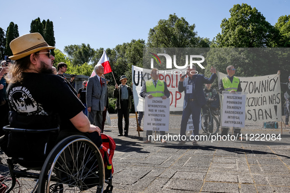 Pro-Russian activists wait for Sergey Andreyev, Russian Ambassador to Poland to arrive to lay flowers at the Mausoleum of the Soviet Soldier...