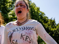 Pro-Ukraine activists shaut and cry as Sergey Andreyev, Russian Ambassador to Poland arrive to lay flowers at the Mausoleum of the Soviet So...