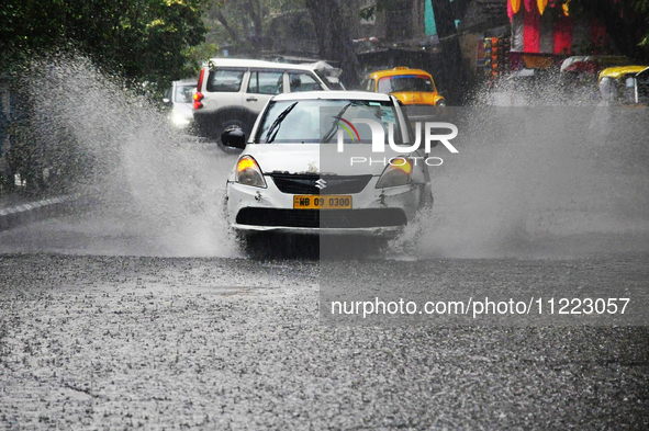 A taxi is navigating a water-logged street during heavy rain in Kolkata, India, on May 9, 2024. 