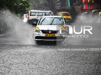 A taxi is navigating a water-logged street during heavy rain in Kolkata, India, on May 9, 2024. (