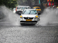 A taxi is navigating a water-logged street during heavy rain in Kolkata, India, on May 9, 2024. (