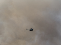 A helicopter is being seen through the thick smoke in Limassol, Cyprus, on May 9, 2024. A wildfire is breaking out at the Industrial Zone of...