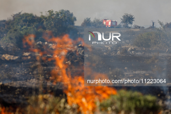 A fire truck is seen in the distance in Limassol, Cyprus, on May 9, 2024. A wildfire is breaking out at the Industrial Zone of Ipsonas, a fe...