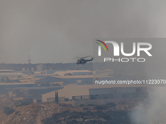 A helicopter is flying over industrial sites in Limassol, Cyprus, on May 9, 2024. A wildfire has broken out at the Industrial Zone of Ipsona...