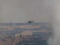 A helicopter is flying over industrial sites in Limassol, Cyprus, on May 9, 2024. A wildfire has broken out at the Industrial Zone of Ipsona...