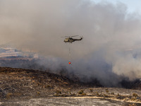 A helicopter is operating during a fire in Limassol, Cyprus, on May 9, 2024. The wildfire, which broke out in the Industrial Zone of Ipsonas...