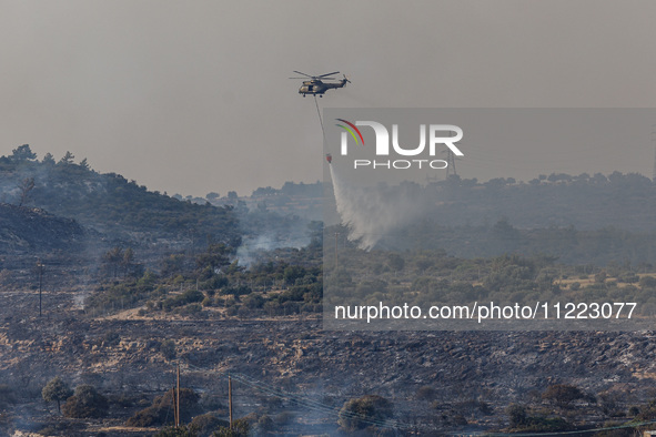 A helicopter is operating during a fire in Limassol, Cyprus, on May 9, 2024. The wildfire, which broke out in the Industrial Zone of Ipsonas...