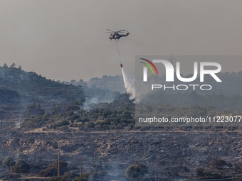 A helicopter is operating during a fire in Limassol, Cyprus, on May 9, 2024. The wildfire, which broke out in the Industrial Zone of Ipsonas...