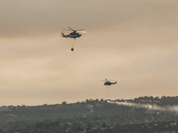 Helicopters are flying over the area during a fire in Limassol, Cyprus, on May 9, 2024. The wildfire, which started in the Industrial Zone o...