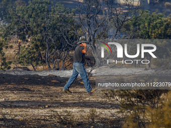 A volunteer is talking on his phone during a fire in Limassol, Cyprus, on May 9, 2024. The wildfire, which broke out in the Industrial Zone...