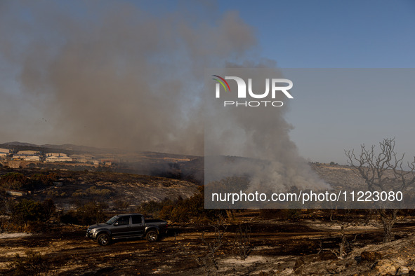 Smoke is rising from a fire in Limassol, Cyprus, on May 9, 2024. The wildfire, which broke out in the Industrial Zone of Ipsonas, a few kilo...