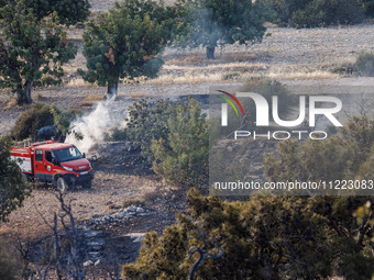 A fireman is putting out a small fire in Limassol, Cyprus, on May 9, 2024. The wildfire, which broke out in the Industrial Zone of Ipsonas a...