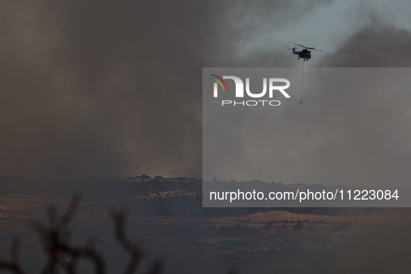 A helicopter is operating during a fire in Limassol, Cyprus, on May 9, 2024. The wildfire, which broke out in the Industrial Zone of Ipsonas...