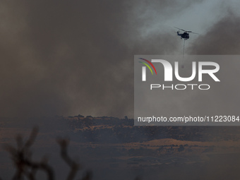 A helicopter is operating during a fire in Limassol, Cyprus, on May 9, 2024. The wildfire, which broke out in the Industrial Zone of Ipsonas...