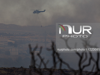 A helicopter is operating during a fire in Limassol, Cyprus, on May 9, 2024. The wildfire, which broke out in the Industrial Zone of Ipsonas...