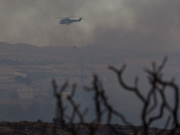 A helicopter is operating during a fire in Limassol, Cyprus, on May 9, 2024. The wildfire, which broke out in the Industrial Zone of Ipsonas...