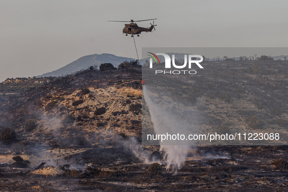 A helicopter is operating during a fire in Limassol, Cyprus, on May 9, 2024. The wildfire, which broke out in the Industrial Zone of Ipsonas...