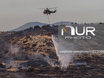 A helicopter is operating during a fire in Limassol, Cyprus, on May 9, 2024. The wildfire, which broke out in the Industrial Zone of Ipsonas...